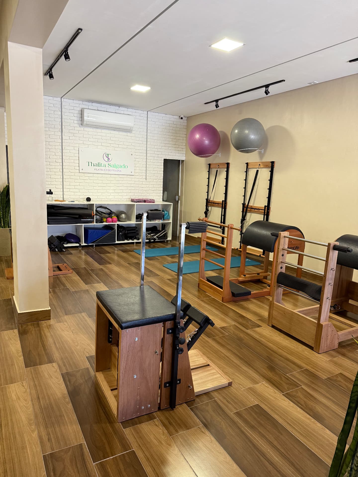 Ambiente do estúdio com aparelhos de Pilates e acessórios organizados